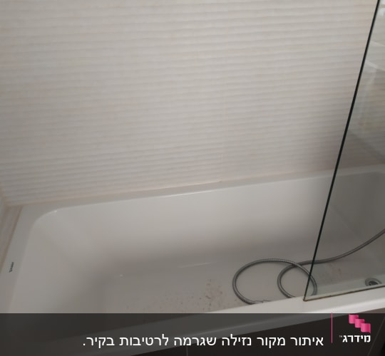 אמבטיה עם צינור מתכת ומחיצה זכוכית